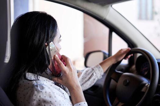 Unsafe driving. Young multiracial woman talking on the phone while driving. Distracted Driving. Female driving and talking on cellphone