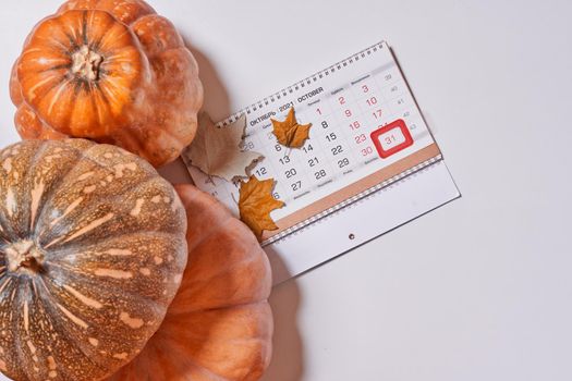 October 2021 monthly calendar and pupmkins on white background. Top view. Overhead view of Autumn month - October calendar