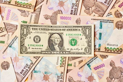 US dollar banknote and Uzbek sums. Concept of exchange rate, Uzbek sum to us dollar. Money exchange in Uzbekistan. Pile of Uzbek money sum and American dollar bill