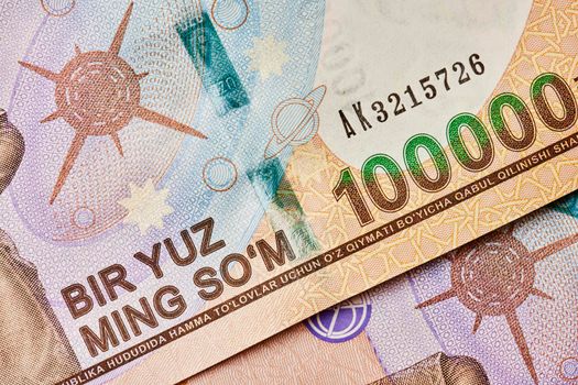 Macro shot of uzbek sum banknote. Pile of Uzbek sums. Uzbek currency money bill. A stack of one hundred thousand Uzbek sum. 100000 sum