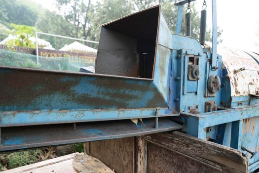 Old rusted machinery painted in blue color kept under sunglight.