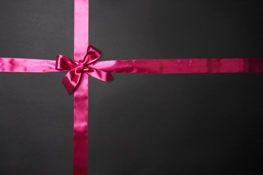 Creative Black Friday concept made with pink ribbon on dark background