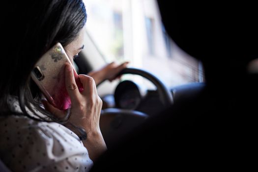 Unsafe driving. Young multiracial woman talking on the phone while driving. Distracted Driving. Female driving and talking on cellphone