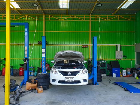 Bangkok, Thailand - July 17, 2021 : Unidentified car mechanic or serviceman checking a car engine for fix and repair problem at car garage or repair shop