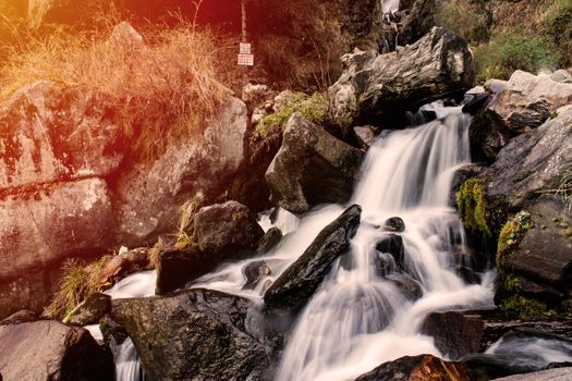 Beautiful waterfall of silky water going down the mountain at the time of sunset