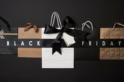 Black friday concept. Pile of various shopping bags on black background.