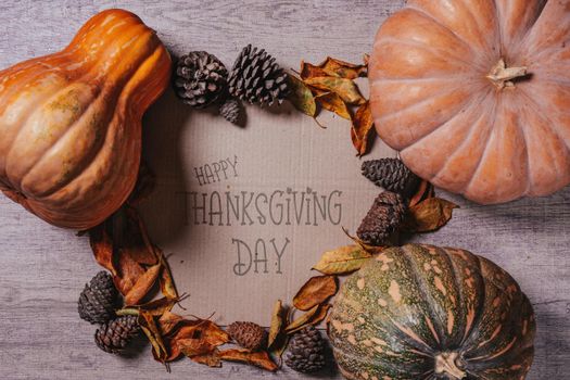 Happy thanksgiving day - Autumnal background with harvest fall vegetables and autumnal leaves on wooden background