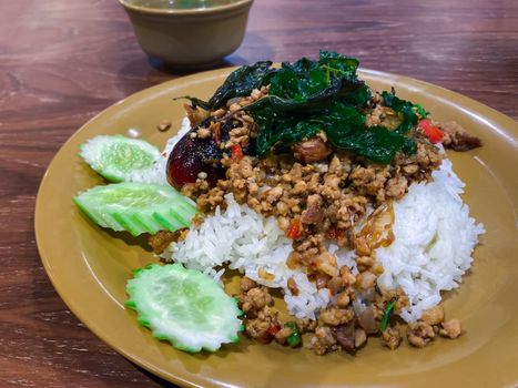 Rice topped with stir-fried pork or beef and basil for sale at Thai street food market or restaurant in Bangkok Thailand