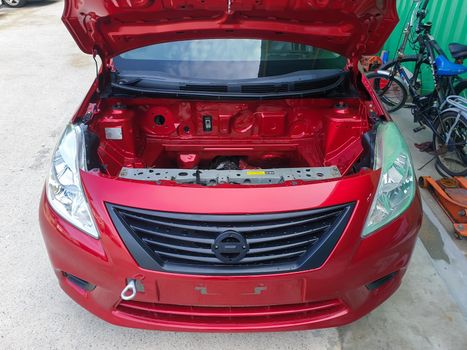 Bangkok, Thailand - August 7, 2021 : Unidentified denter or car mechanic serviceman check and fix body work and fiber bumper body part for fix and repair problem at car garage or repair shop