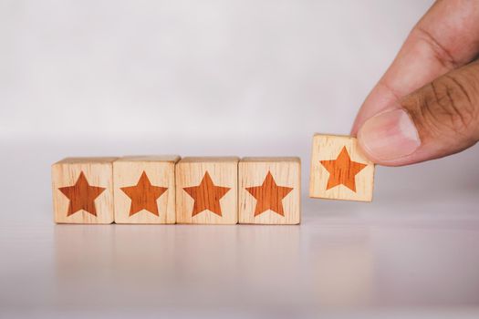 Hands of customer holding cube wooden block with five star vote rating, review and feedback of quality and satisfaction, guarantee and excellent for successful, warranty and score, business concepts.