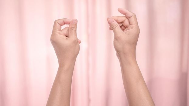 Hands snapping fingers isolated on pink background. Isolated female hands flicking fingers to the rhythm of the music. Sign language.