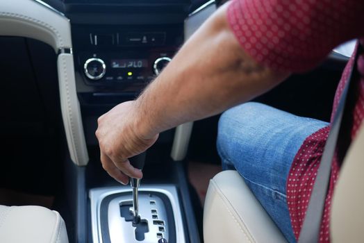 Male hand changing gear in the car