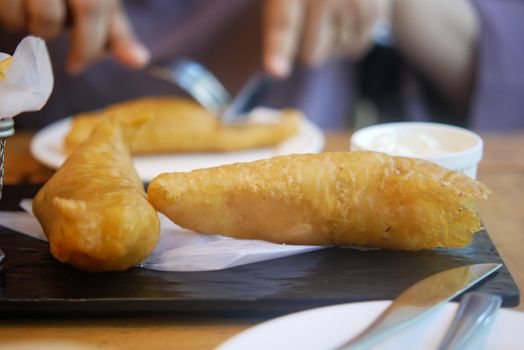 Fish fillet , chips and potato mash on table .