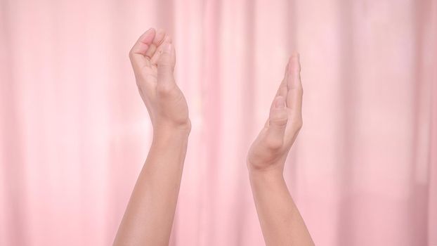 Hands applauding isolated on pink background. Isolated female hands applauding symbol of appreciation. Sign language.