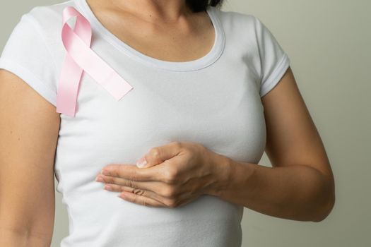 pink badge ribbon on woman chest to support breast cancer cause. breast cancer awareness concept