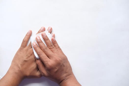 man disinfecting his hands with a wet wipe