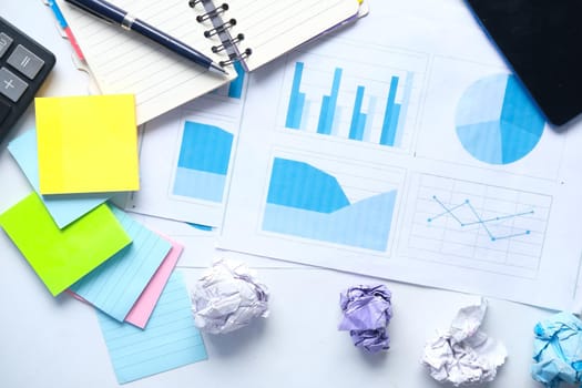 financial graph, calculator and notepad on table.
