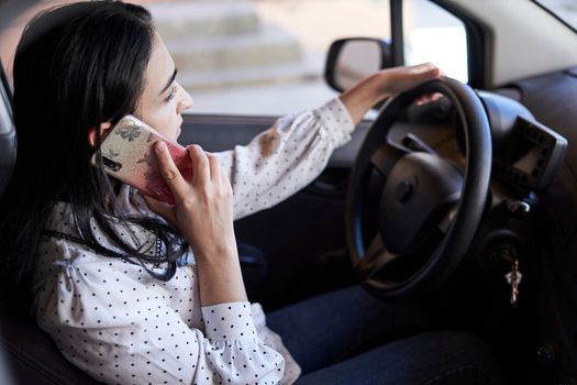 Unsafe driving. Young multiracial woman talking on the phone while driving. Distracted Driving. Female driving and talking on cellphone