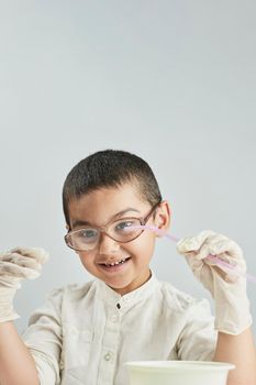 Vertical portrait of a happy schoolboy having fun with at classroom