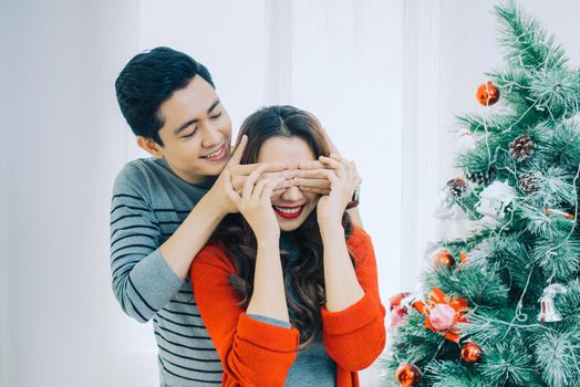 Christmas Asian Couple.Happy Smiling Family at home celebrating.New Year People