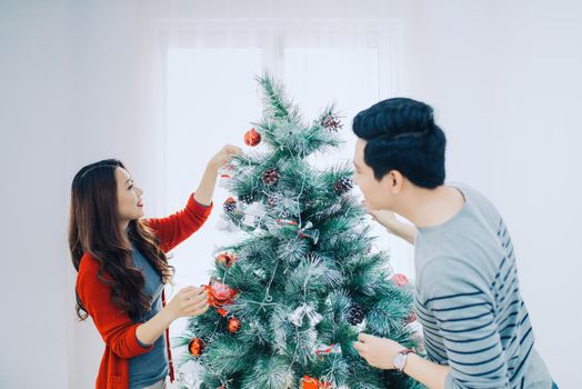 Christmas Asian Couple.Happy Smiling Family at home celebrating. New Year People