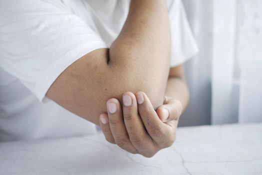 man with elbow pain. Pain relief concept