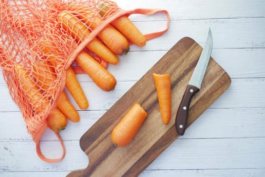 fresh carrots on chopping board on table .
