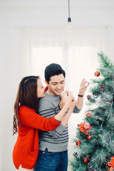 Christmas Asian Couple.Happy Smiling Family at home celebrating. New Year People