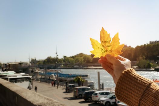 Happy Thanksgiving Day with Maple leave on woman hand and text