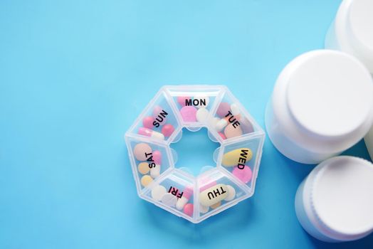 medicine pill box and container on blue background .