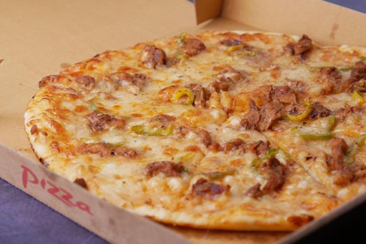 Slice of cheese pizza in a paper box on table .