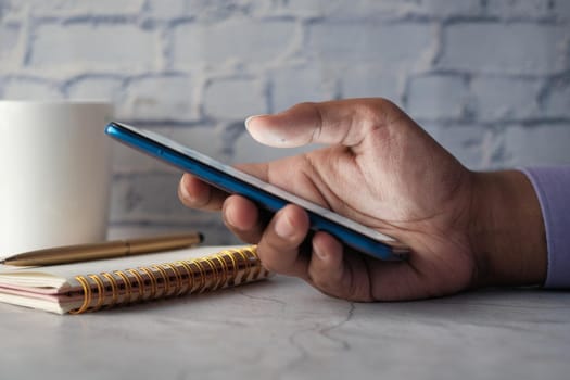 Close up of young man hand using smart phone