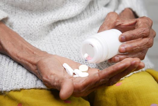 senior women hand's taking medicine, close up .