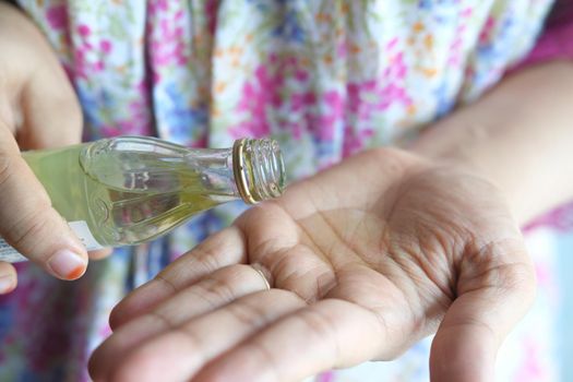 pouring hair oil on hand close up .