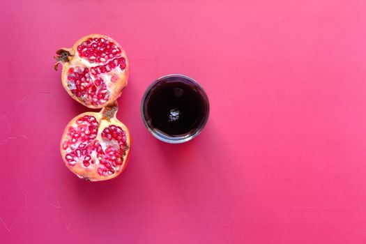 glass on pomegranate juice and fresh fruits on red background