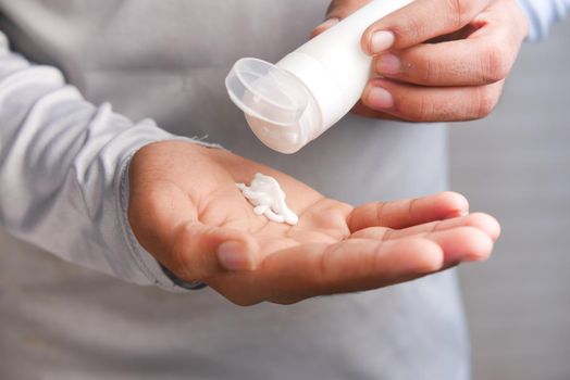 man applying beauty cream onto skin .
