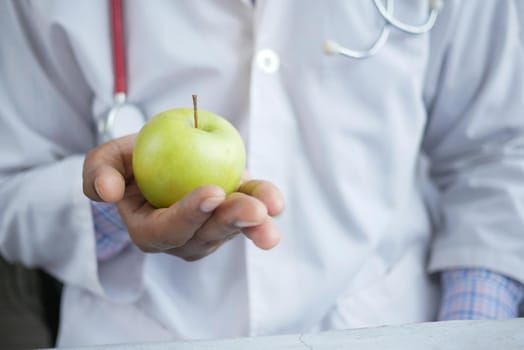 doctor's hand holding green apple while sited ,