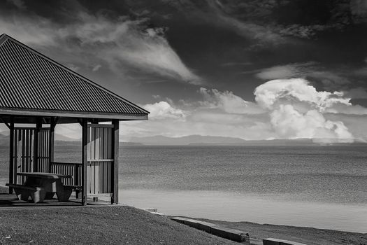 Black and white of a shaded structure with verandah suitable for the public to relax at a dam popular for recreation