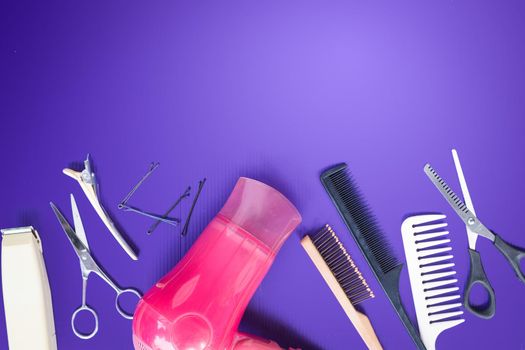 Hairdresser set with comb on top of purple background.