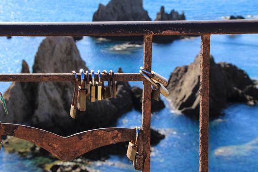 Romantic padlocks hanging on The Reef of the Sirens railing in Cabo de Gata-Nijar, Almeria, Spain
