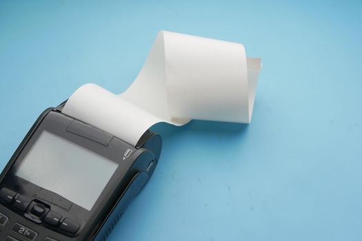 POS machine and long rolling paper on blue