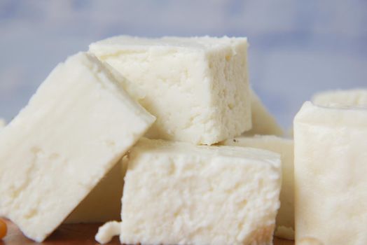 close up of cube shape fresh cheese in a bowl ,