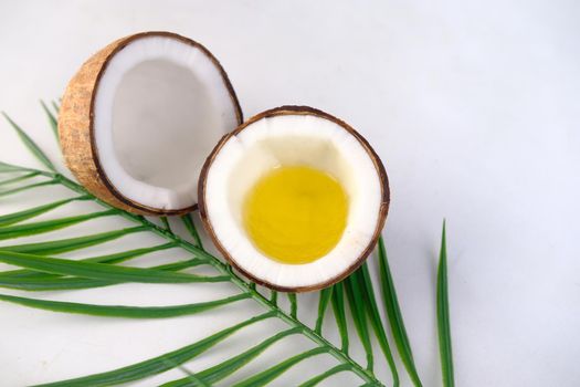 slice of fresh coconut and oil on white background with copy space