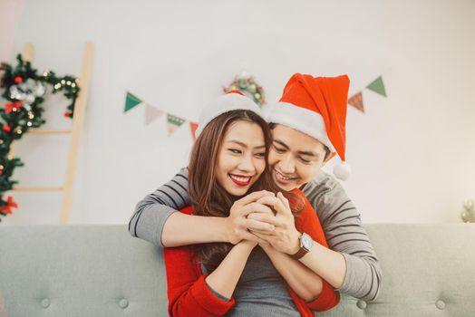 Christmas Asian Couple.Happy Smiling Family at home celebrating. New Year People