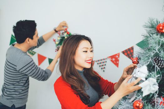 Christmas Asian Couple.Happy Smiling Family at home celebrating. New Year People