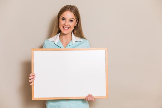 Portrait of medical nurse holding whiteboard.