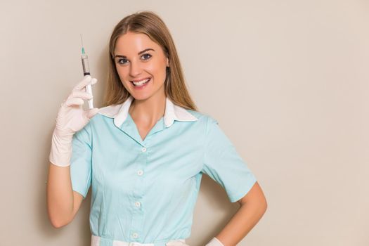Portrait of medical nurse holding injection.