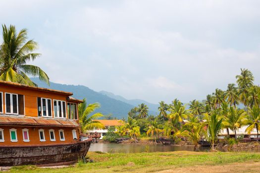 hotel in the shape of a ship in the tropics, among coconut trees and a river