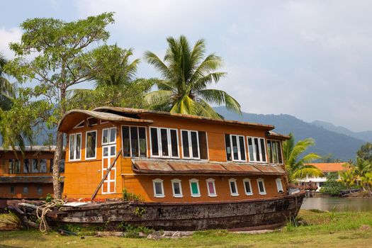 a ship-shaped hotel in the tropics among coconut trees and mountains