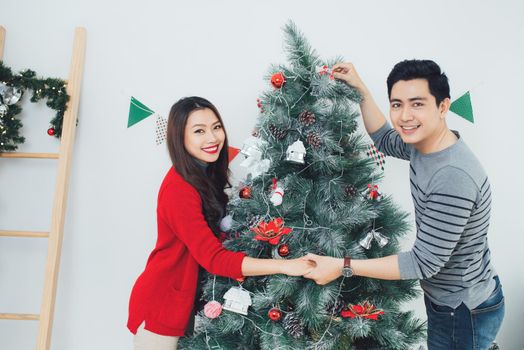 Christmas Asian Couple.Happy Smiling Family at home celebrating. New Year People